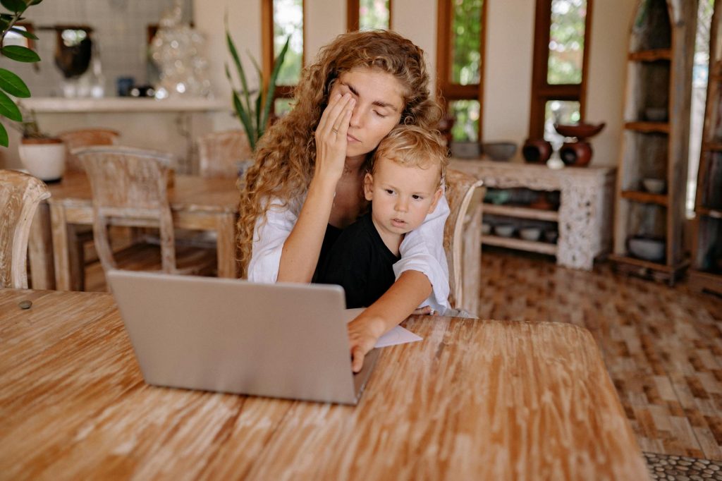 a mother using laptop with her son