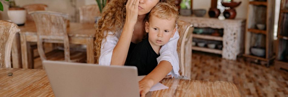 a mother using laptop with her son