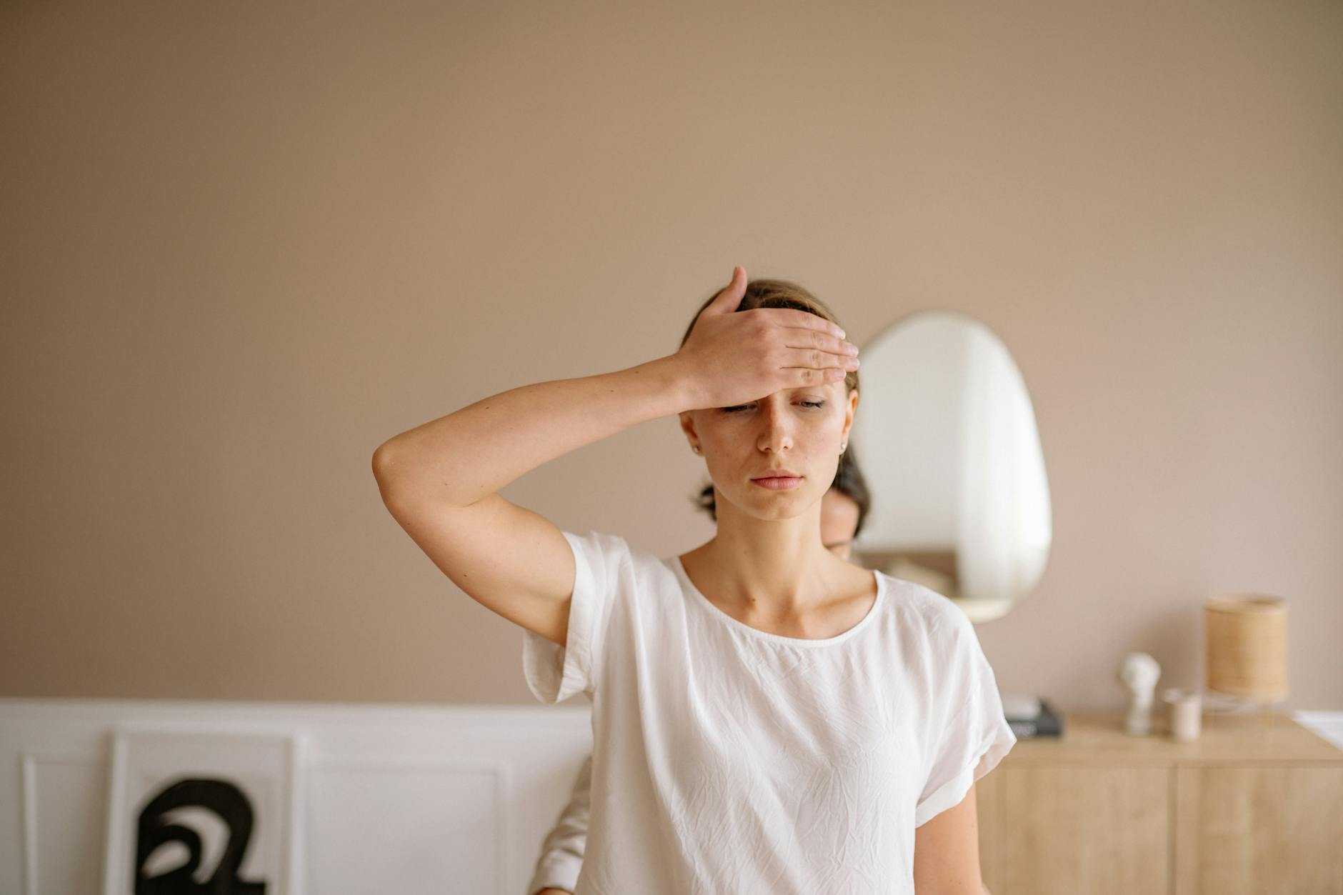 a woman touching her forehead