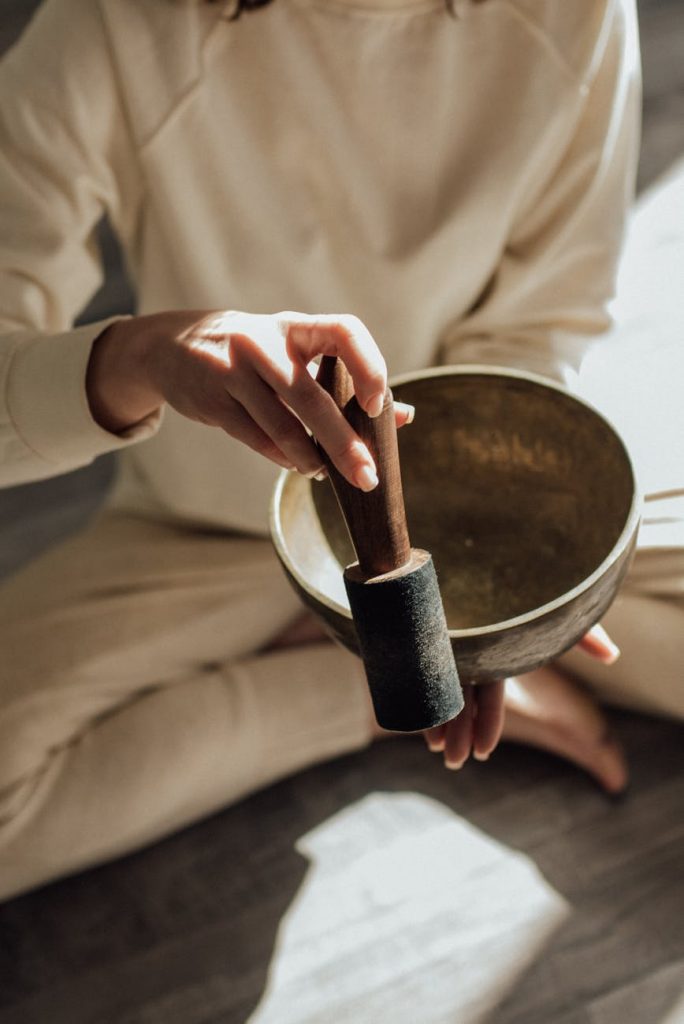 a person holding a mallet and a singing bowl