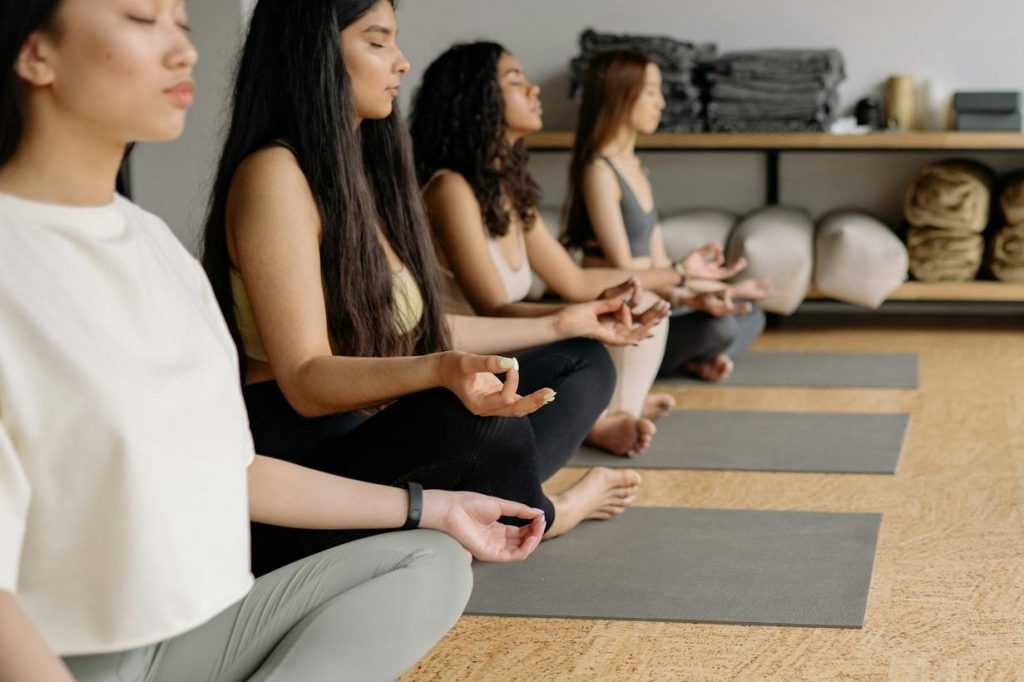 a man instructing yoga to a group of women