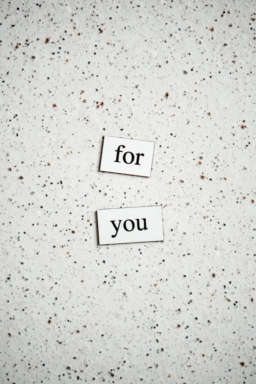 two text cutout papers on a flat surface